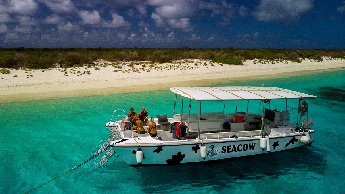 Catamaran anchored off Klein Bonaire with snorkelers in the water on a Bonaire snorkeling tour from Kralendijk